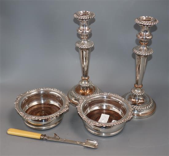 A pair of Sheffield plate candlesticks, a pair of plated wine coasters and a patent action plated stilton scoop